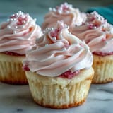 Moist, airy Pink Velvet Cupcakes with fluffy swirls of vanilla buttercream, topped with edible pink sanding sugar.