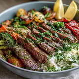 The Sheet Pan Steak and Veggie Bowl features tender sliced steak, caramelized onions, and vibrant veggies served over aromatic jasmine rice.