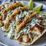 Zesty coconut milk-marinated fish grilled to perfection, served in warm tortillas with fresh cabbage slaw and creamy lime sauce.  