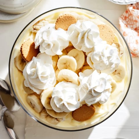 Sliced bananas and vanilla wafers nestled in rich, homemade vanilla pudding, finished with fluffy whipped cream for a classic Southern dessert.