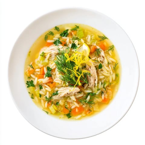 A comforting Chicken Lemon Orzo Soup served hot, featuring tender chicken, carrots, celery, and a bright squeeze of lemon.