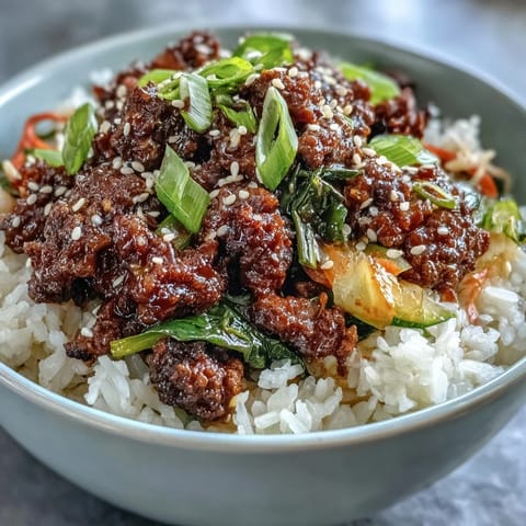 A deconstructed Korean Ground Beef Bowl showing a skillet of beef with sesame oil and a bowl of tangy pickled vegetables.
