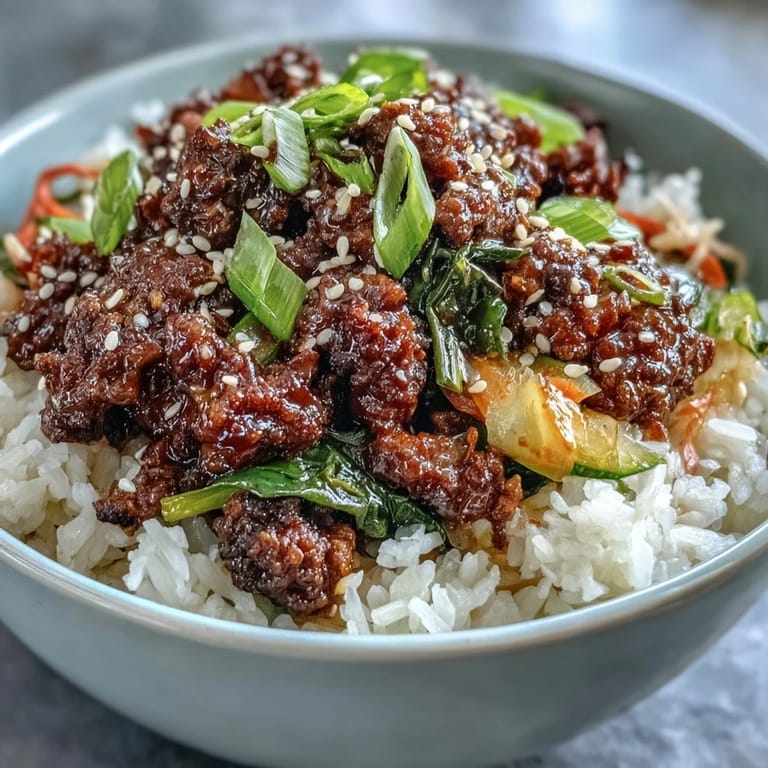 A deconstructed Korean Ground Beef Bowl showing a skillet of beef with sesame oil and a bowl of tangy pickled vegetables.