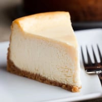 Freshly sliced New York cheesecake reveals its dense, creamy texture on a graham cracker crust, perfect for a special occasion dessert.