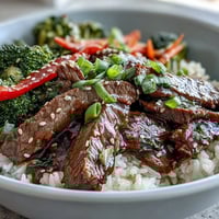 Fluffy white rice topped with glazed Teriyaki Beef Bowl, featuring tender beef, crisp broccoli, and carrots.
