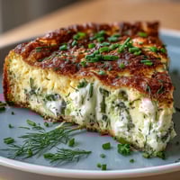 A golden spring frittata with asparagus, goat cheese, and fresh herbs baked to perfection.  